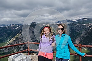 Two female friends 20s pose together at an overlook along Montana Beartooth Pass