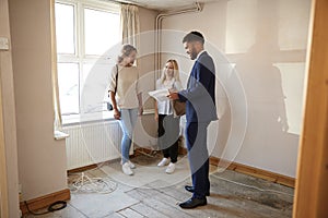 Two Female Friends Buying House For First Time Looking At House Survey With Realtor