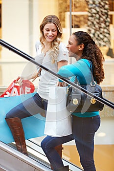 Two Female Friends On Escalator In Shopping Mall