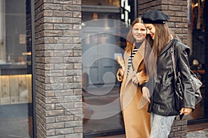 Two female friends in fashion clothes walking on the street