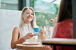 Two female friends having conversation in cafe.