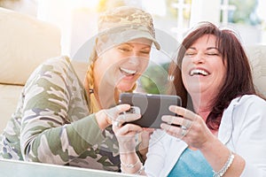 Two Female Friends Laugh While Using A Smart Phone