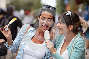 two female friends licking ice cream