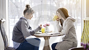 Two female friends meeting in a cafe to eat