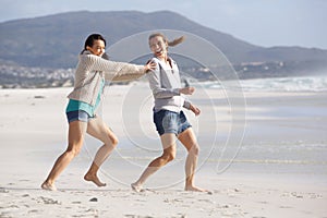 Two female friends playing on the beach