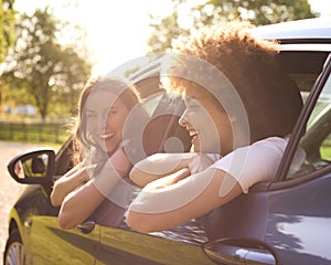 Two Female Friends Or Same Sex Couple In Car On Road Trip Vacation Together Looking Out Of Window