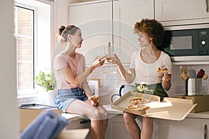 Two Female Friends Or Same Sex Couple Celebrating With Pizza And Wine On Moving Day In New Home