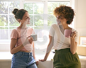 Two Female Friends Or Same Sex Couple Taking A Coffee Break From Unpacking On Moving Day In New Home