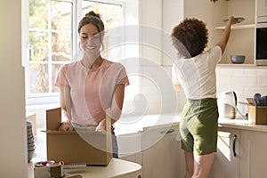 Two Female Friends Or Same Sex Couple Unpacking On Moving Day In New Home