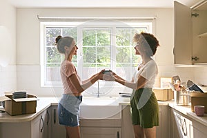 Two Female Friends Or Same Sex Couple Unpacking On Moving Day In New Home