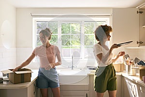 Two Female Friends Or Same Sex Couple Unpacking On Moving Day In New Home