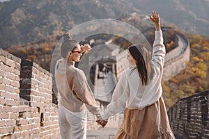 two female friends walking along the Great Wall of China near the Beijing entarnce