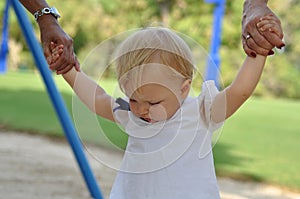 Two female hands holding a little girls