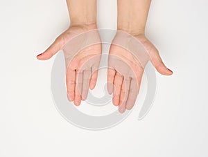 Two female hands with red painted nails in a prayer pose on a white background, top view