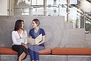Two female healthcare workers discussing a medical record