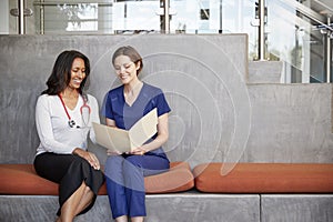 Two female healthcare workers looking at a file together