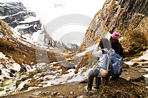 Two female hikers resting while enjoying the serene view of the snowy trek