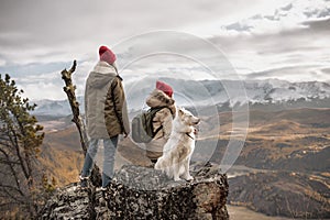 Two female hikers with white dog at mountain top