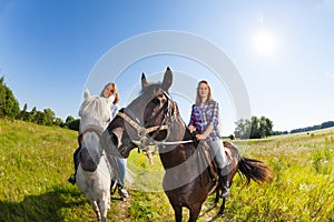 Two female horseback riders mounted on horses