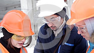 Two female inspectors and architects discuss with head engineer about construction project