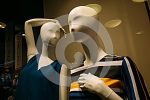 Two female mannequins in a shop window during a sale