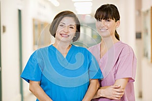 Two Female Nurses Standing In A Hospital Corridor