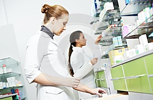 Two female pharmacutical chemists work at drugstore