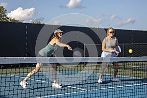 Two Female Pickleball Players at the Net