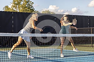 Two Female Pickleball Players in Rally at Net