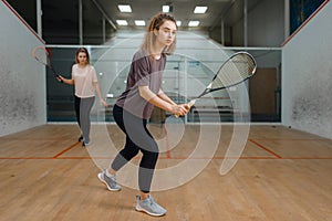 Two female players with rackets, squash game
