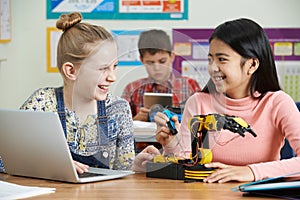 Two Female Pupils In Science Lesson Studying Robotics