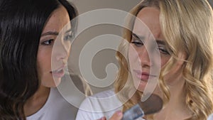 Two female roommates pushing each other standing in front of mirror, rivalry