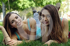 Two female students lie on the grass