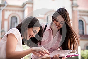 Two female students preparing for exams together outdoors