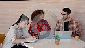 two female students sitting together, there was laptop computer notepad in front, teacher sat down to teach students