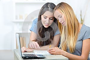 Two female students using laptop