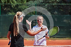 Two female tennis players shaking hands with smiles on a sunny day, exuding sportsmanship and friendship after a