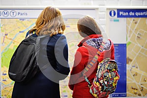 Two female tourist looking at the map of metro
