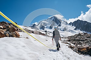 Two females Rope team members on acclimatization day dressed in mountaineering clothes walking in crampons with ice axes by snowy photo