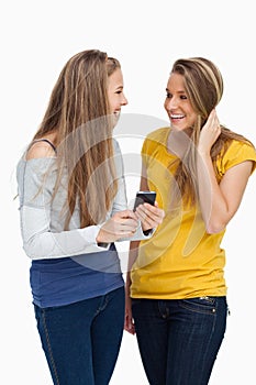 Two females student laughing while holding a cellphone