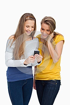 Two females student smiling while looking a cellphone