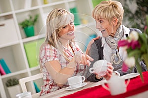 Two females talking and drinking coffee