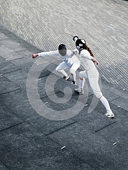 Two fencers fencing outside together