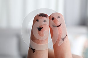 Two fingers with drawings of happy faces on blurred background. Spending time together