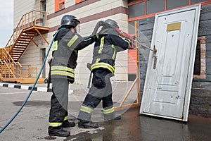 Two firefighters demonstrate lock snapping with photo