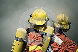 Two firefighters fire fighting suround with dark smoke