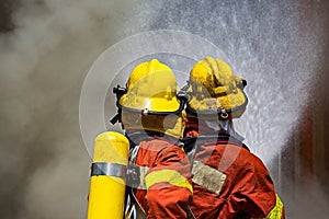 Two firefighters fire fighting surround with dark smoke