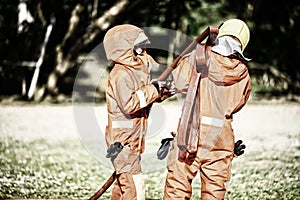 Two firefighters help arrange the water tube to fight the fire. Firefighter prepare dress up and equipment for firefighting