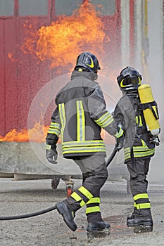 TWO firefighters with oxygen bottles off the fire