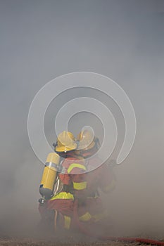 Two firefighters is working surround with smoke